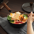 20cm cast iron wok with lid used to serve noodles, highlighting its suitability for single-portion meals.