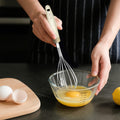 Zhang Xiaoquan 290mm stainless steel whisk beating eggs in bowl, ideal for home baking and kitchen prep.