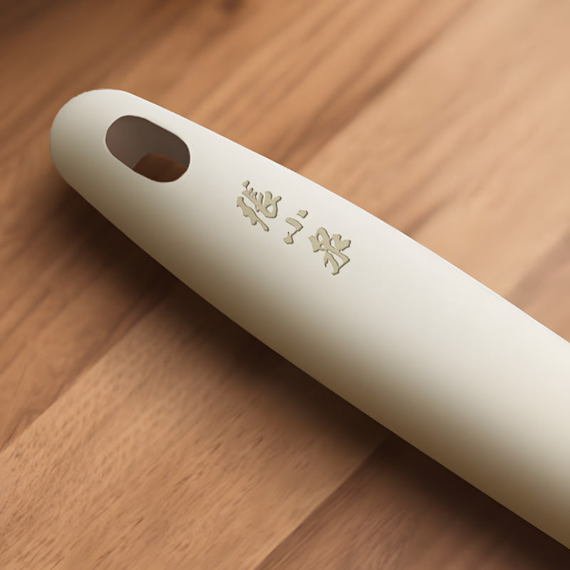 Close-up of the beige ergonomic handle with Zhang Xiaoquan branding, designed for comfort and control in heat-resistant kitchen tools.