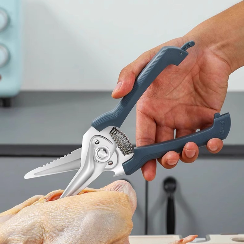 User cutting raw poultry with 30Cr13 spring-assist kitchen shears, demonstrating strength and ease of use in food preparation.