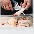 Spring-assisted kitchen shears cutting chicken pieces, ideal for butchering tasks with durable 30Cr13 stainless steel blades.