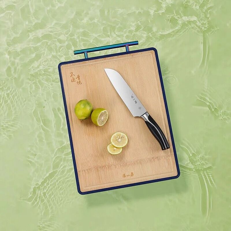 Double-sided bamboo and PP cutting board with anti-spill groove and garlic grinder, ideal for meat and vegetables. Features ergonomic handle design.