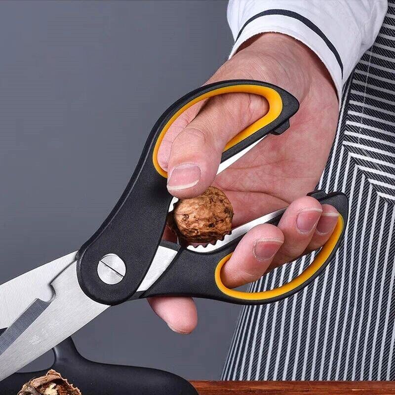User cracking a walnut using the built-in nutcracker of the 4-in-1 kitchen scissors. Ergonomic grip ensures safe and easy use.