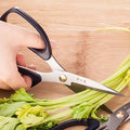 185mm 30Cr13 Multi-Purpose Scissors cutting celery, demonstrating versatility for kitchen and food preparation tasks.