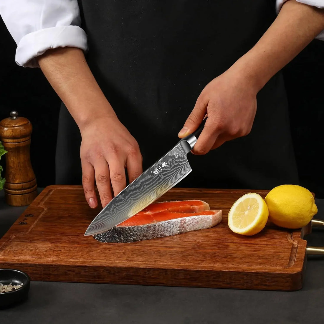 67-layer VG-10 Damascus chef's knife with black pakkawood handle beside fresh vegetables and meat. Ideal for precise kitchen slicing tasks.