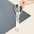Magnetic sheath holding 5-in-1 kitchen scissors vertically on a wall, demonstrating convenient storage and accessibility in the kitchen.