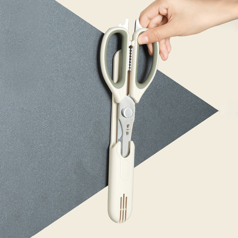 Magnetic sheath holding 5-in-1 kitchen scissors vertically on a wall, demonstrating convenient storage and accessibility in the kitchen.