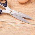 185mm 30Cr13 Multi-Purpose Scissors with partially open blades on a wooden surface, ideal for fabric, meat, and vegetable cutting.