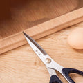185mm 30Cr13 Multi-Purpose Scissors placed on a wooden surface near an egg, highlighting its kitchen utility and durable design.