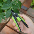 User holding 160mm SK5 Steel Pruning Shears to trim houseplant leaves, highlighting lightweight design and comfortable grip.