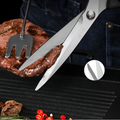 Close-up of BBQ shears cutting grilled meat on a barbecue grill.