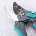 Pruning shears with water droplets highlighting rust-resistant blade.