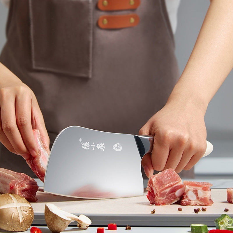 The Chef's Cutting & Sharpening Kit featuring a 305mm cleaver being used to cut raw meat on a kitchen countertop, showcasing its precision and sharpness.