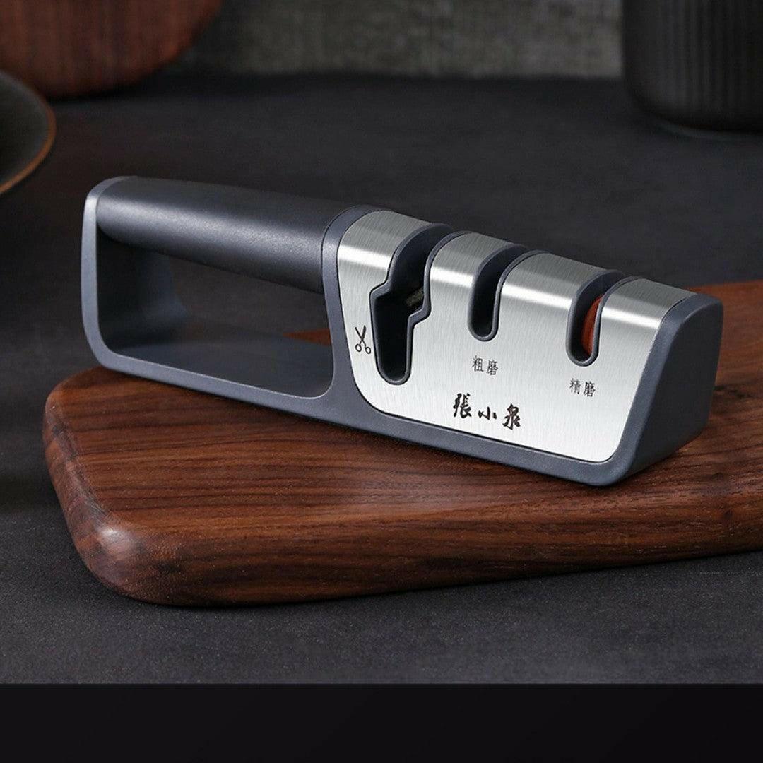 Stylish knife sharpener with three slots on a wooden surface.