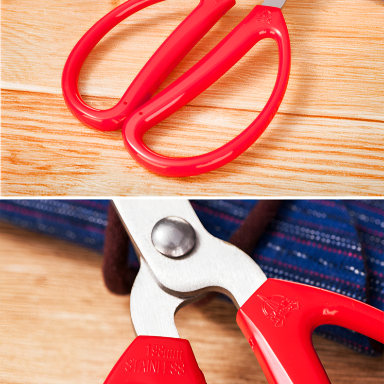 Detailed view of red ergonomic handles and stainless steel blades of scissors.