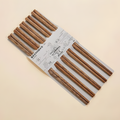 Pack of 5 pairs of chicken wing wood chopsticks in eco-friendly packaging.