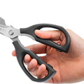 Ergonomic black-handled kitchen shears being held, emphasizing their comfortable grip and sturdy design.