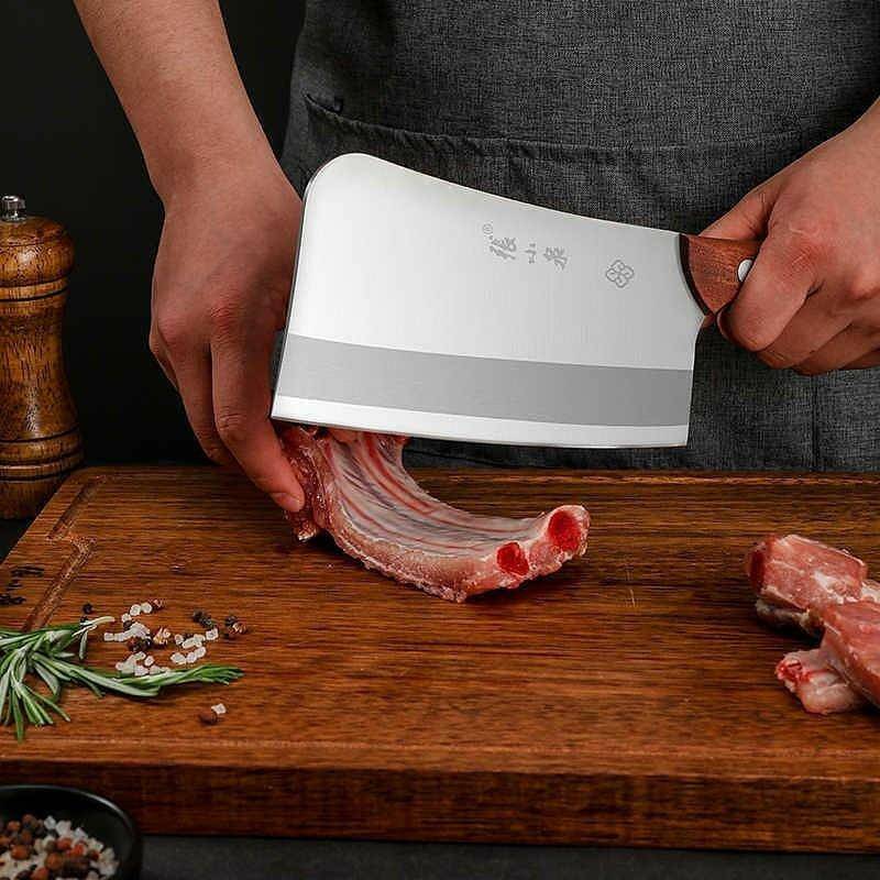 Chinese cleaver cutting raw meat on a wooden board, ergonomic design.