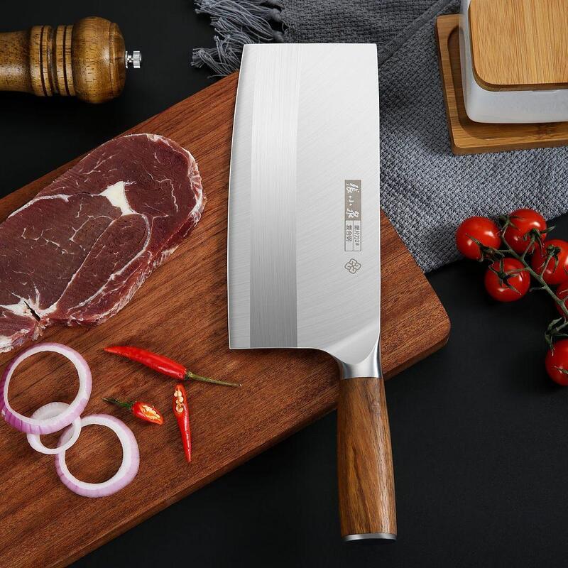 Chinese cleaver knife displayed with fresh ingredients on a wooden cutting board.