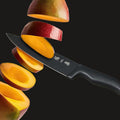 Chef knife slicing a mango, demonstrating sharp blade precision.