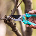 185mm pruning shears cutting a tree branch, highlighting sharp PTFE-coated blade.