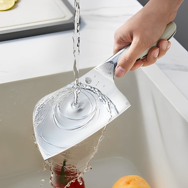 Chinese cleaver being rinsed under running water in a kitchen sink.